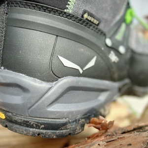 Die Fersenkappe des Salewa Ms Alp Trainer Mid im Detail. Das Bild zeigt die solide Kunststoffverstärkung mit Vibram-Sohle und Logoprägung.