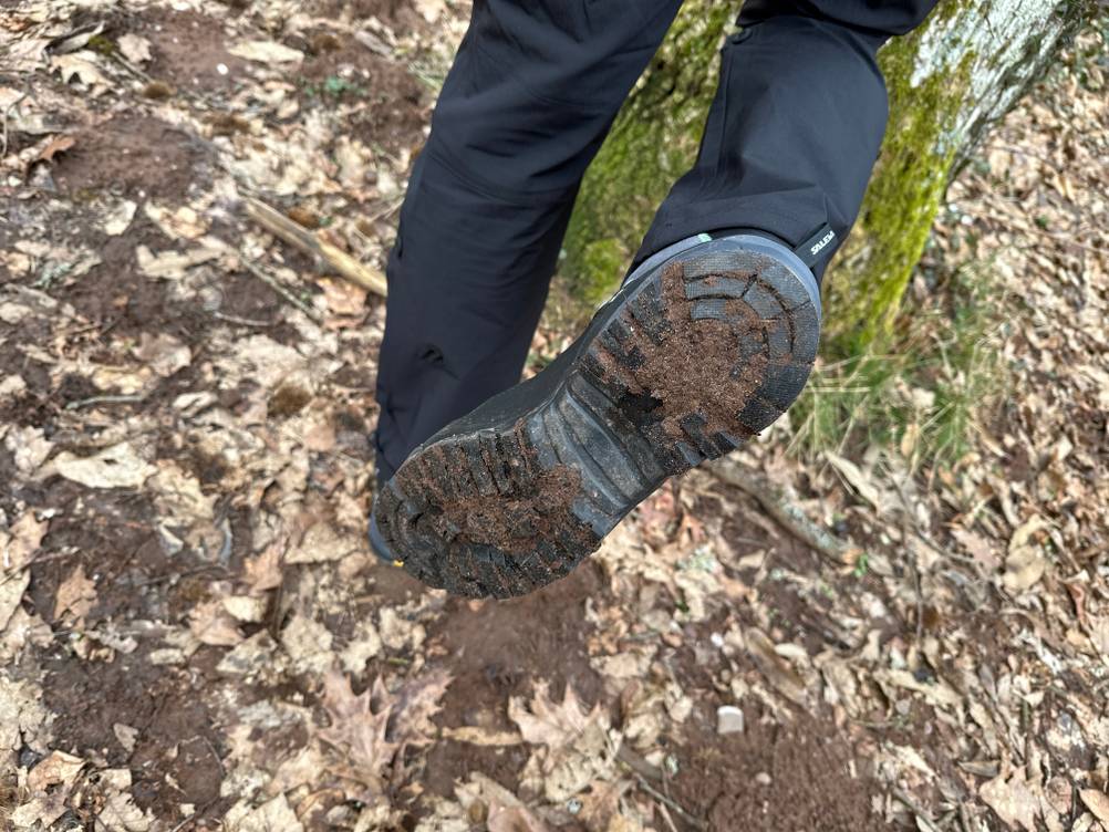 Die Sohle des Salewa Ms Alp Trainer Mid nach dem Einsatz im Gelände. Erd- und Blattrückstände sind im Profil sichtbar.