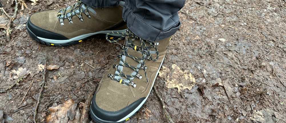 Der Skechers-Relment-Pelmo-Wanderschuh wird auf einem Waldweg getragen. Die braunen Schuhe mit robustem Profil sitzen fest am Fuß.