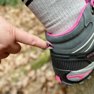 Rückansicht des CMP Rigel Mid mit einer Hand, die an der Einstiegsschlaufe zieht. Die Szene spielt im Wald.