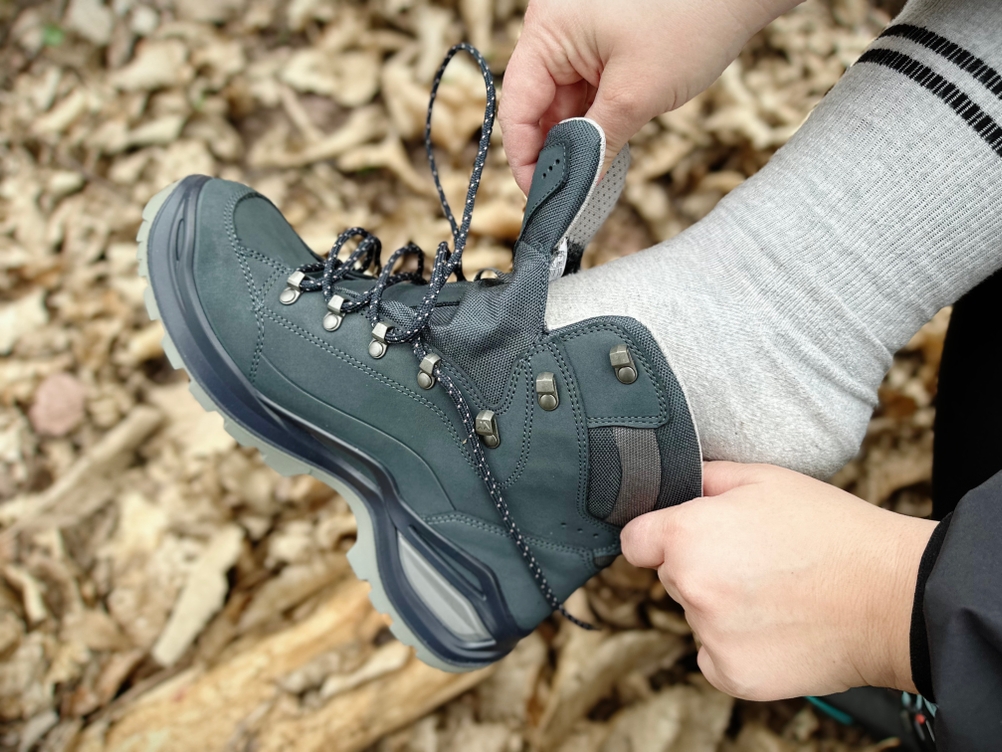 Eine Person zieht den Lowa Renegade EVO GTX MID an. Der Fuß gleitet in den halb geöffneten Schuh.