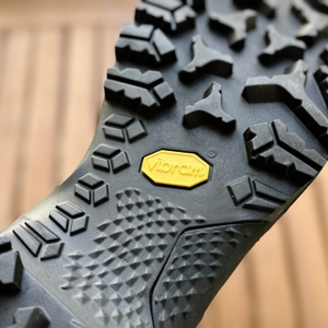 Seitenansicht eines einzelnen Salewa MTN Trainer Mid GTX auf Holztisch. Der Schuh steht leicht seitlich gedreht.