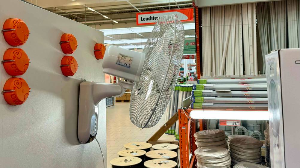 Getestet: Ein Wandventilator von der Seite in einem Laden an eine Wand moniert.