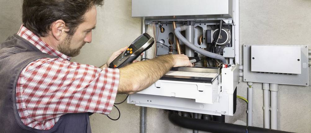 Techniker untersucht routinemäßig einen Brennwertkessel.