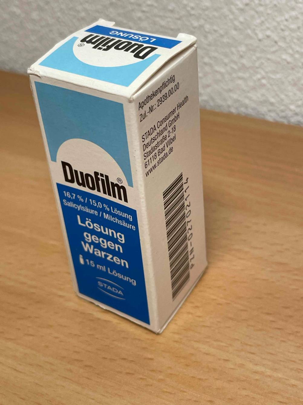 Getestet: Das Warzenmittel in seiner Verpackung auf einer Holzfläche.