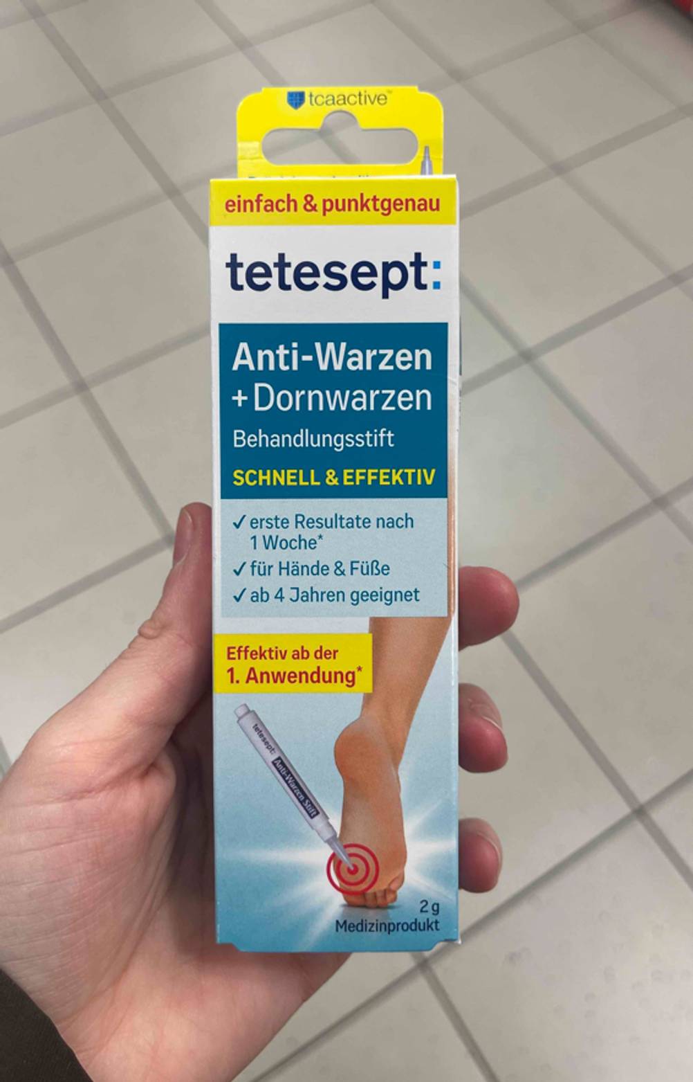 Der Warzenstift im Test liegt innerhalb der Tetesept-Verpackung in einer Handfläche.