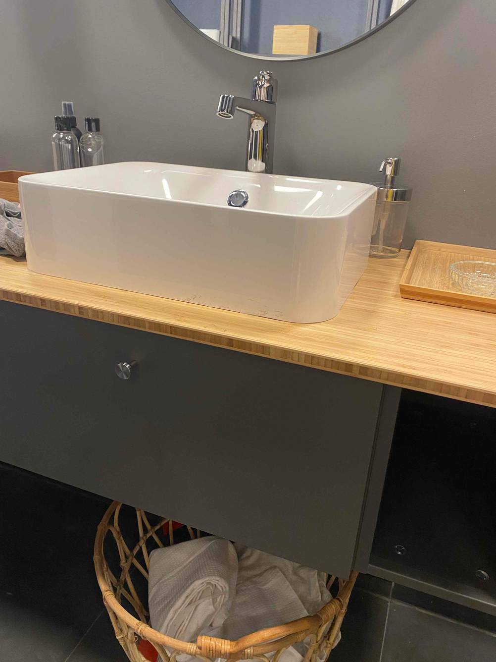 Ein getestetes Waschbecken auf einem Waschbeckenschrank montiert, darunter ein Korb.