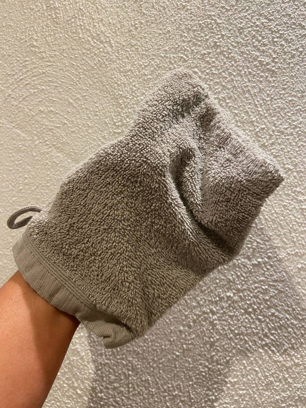 Eine Hand steckt in dem Waschhandschuh im Test.