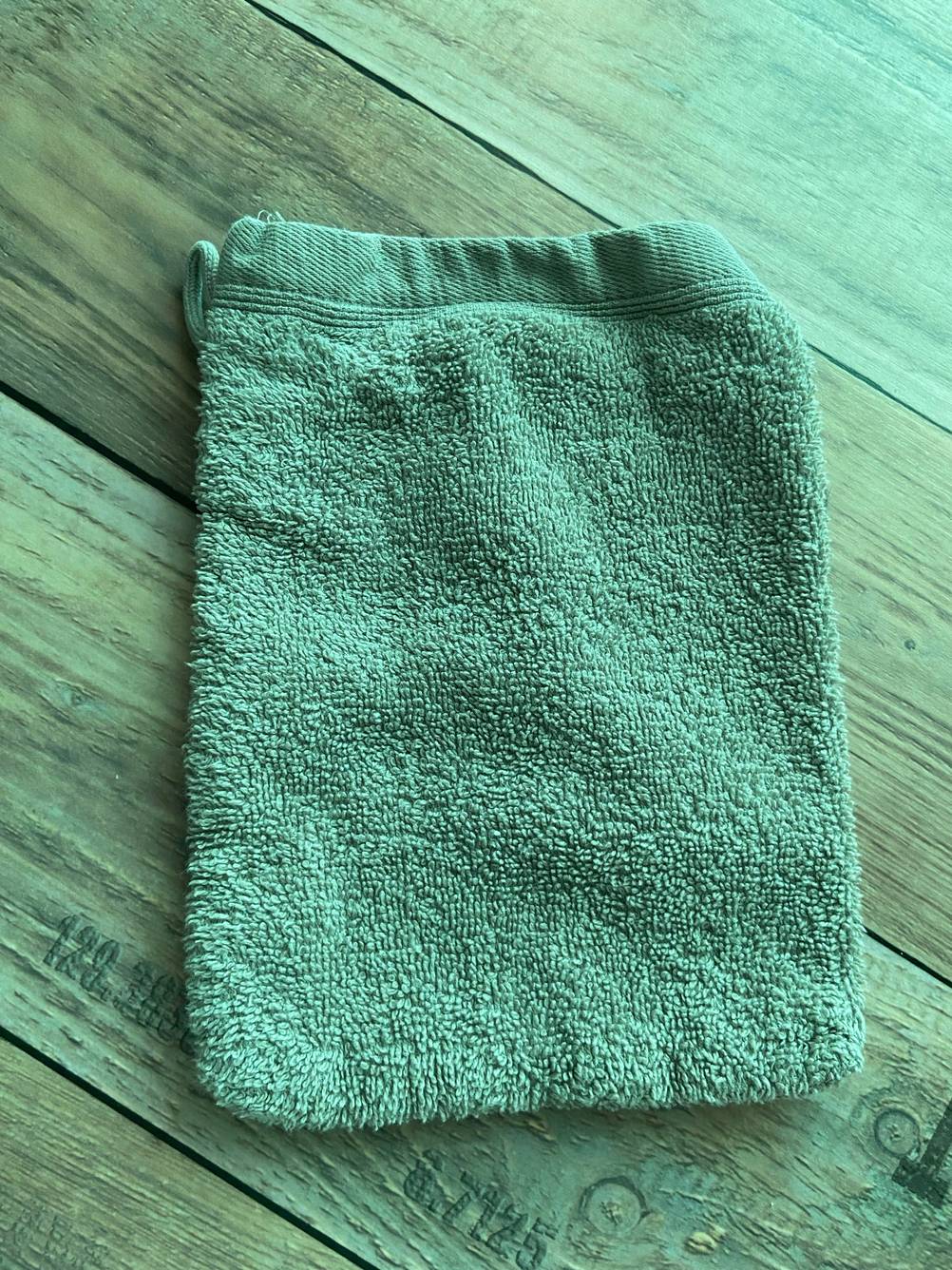 Auf einer Holzfläche liegt der getestete Waschhandschuh.