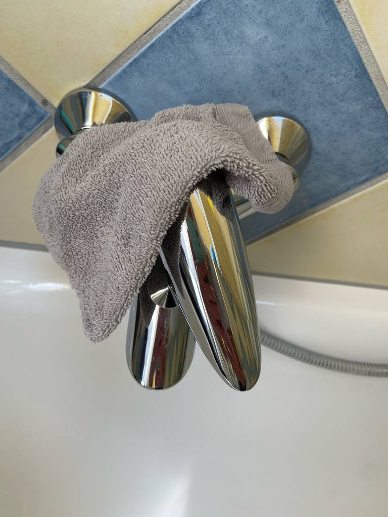 Ein getesteter Waschlappen liegt über einem Wasserhahn.