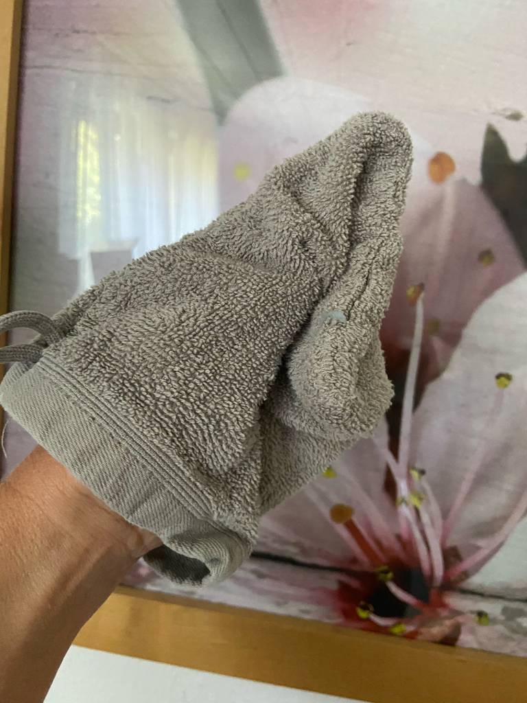 Eine Hand testet einen Waschlappen.