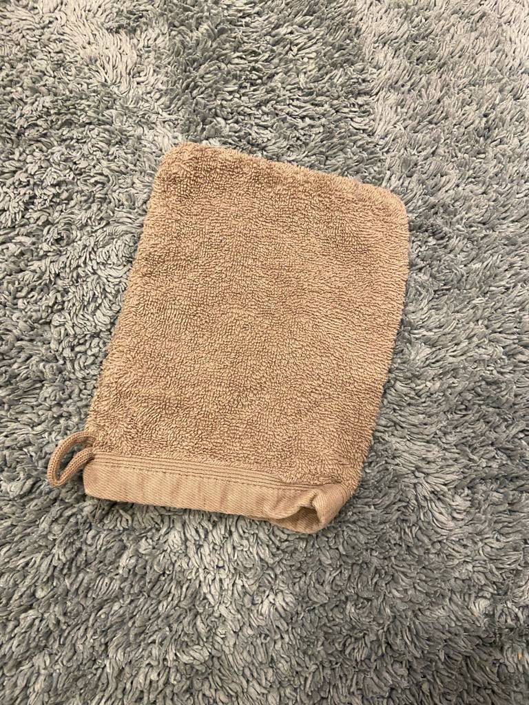 Ein Waschlappen liegt zum testen auf einem grauen Teppich.