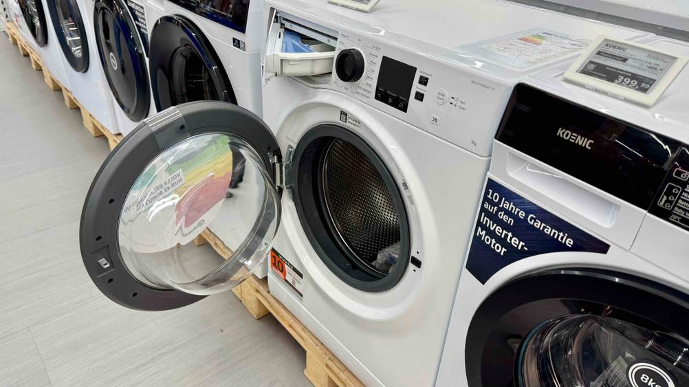 Getestet: Eine Waschmaschine bis 500 Euro mit geöffeter Klappe zwischen anderen Geräten.