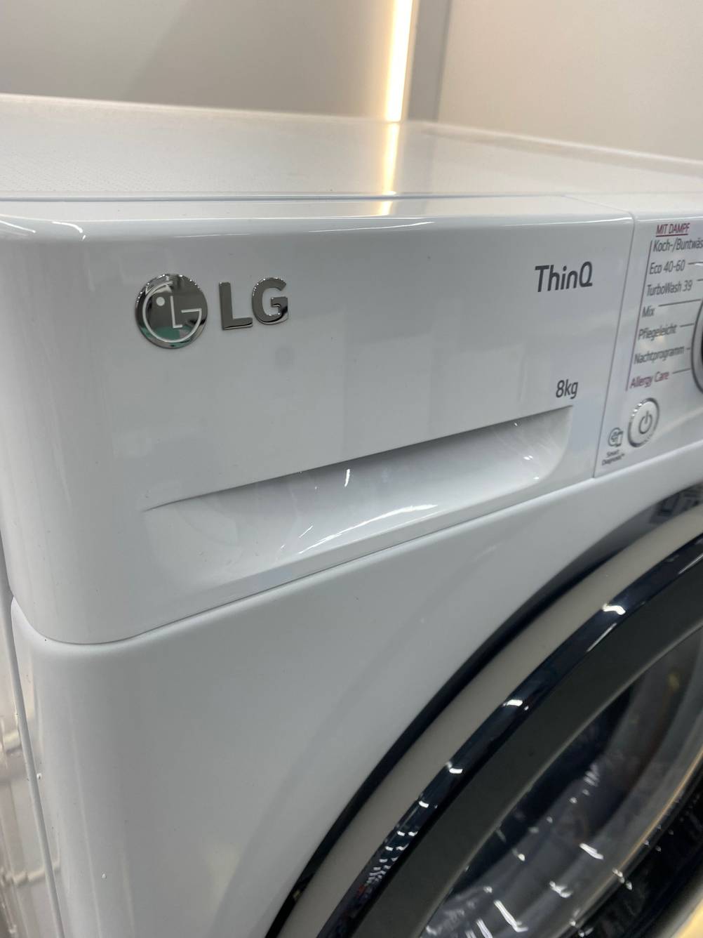 Nahaufnahme des Waschmittelbehälters mit Logo einer getesteten Waschmaschine.