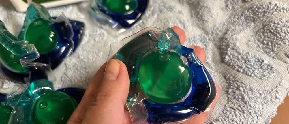 Waschmittel-Pods im Test: Waschmittelpods aus einer Packung in der Hand gehalten.