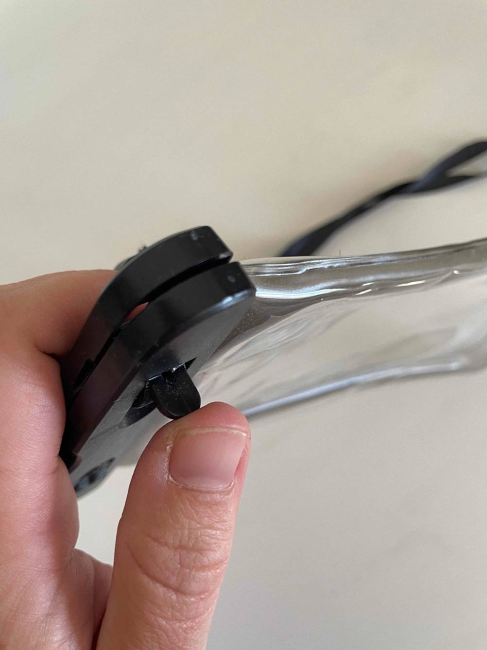 Wasserdichte Handyhülle getestet: Eine Hand drückt mit dem Daumen die Verriegelung.