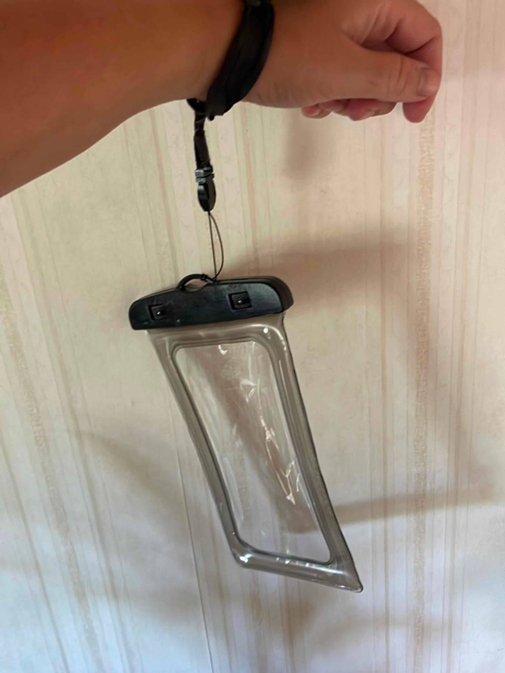 Im Test: Eine wasserdichte Handyhülle hängt an einem Arm.