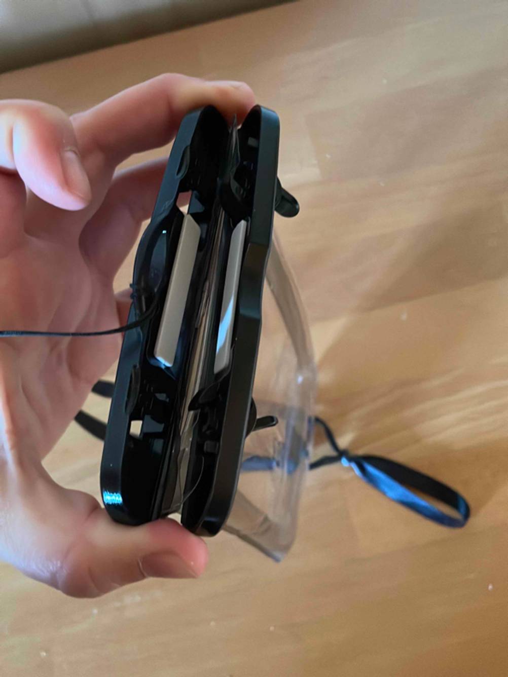 Hand zeigt eine getestete offene wasserdichte Handyhülle von oben.
