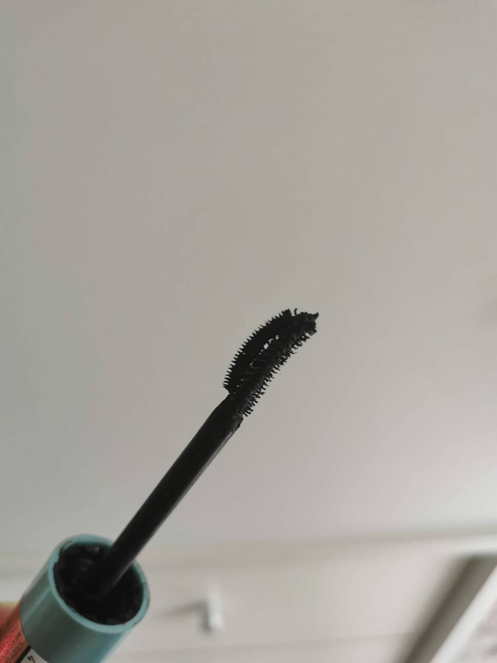 Nahaufnahme des Applikators der getesteten wasserfesten Mascara vor einem hellen Hintergrund.