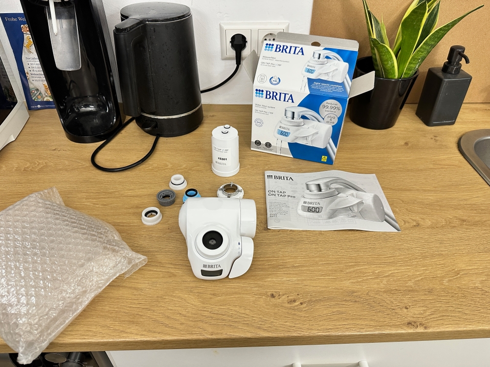 Der Lieferumfang eines Brita-Wasserfilters liegt auf einem Tisch.