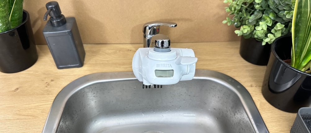 Ein Brita-Wasserfilter ist an einem Wasserhahn montiert.