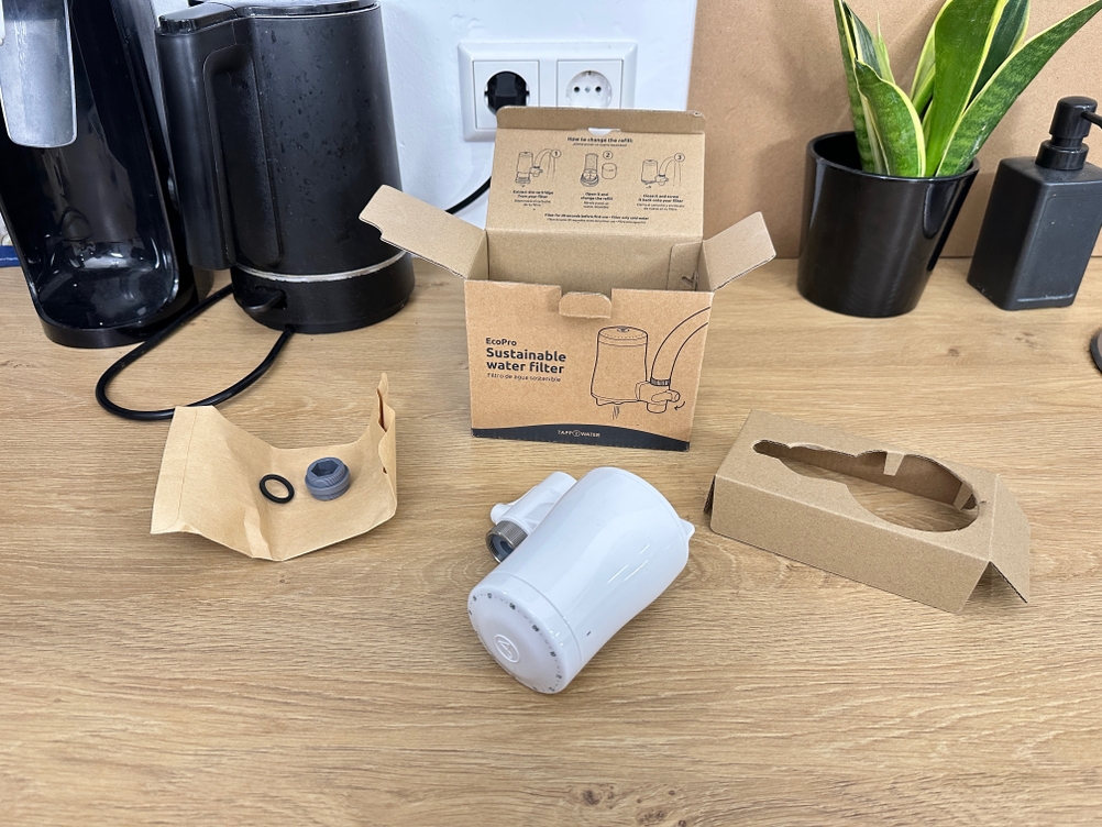 Der Lieferumfang eines Tapp-Wasserfilters liegt auf einem Tisch.