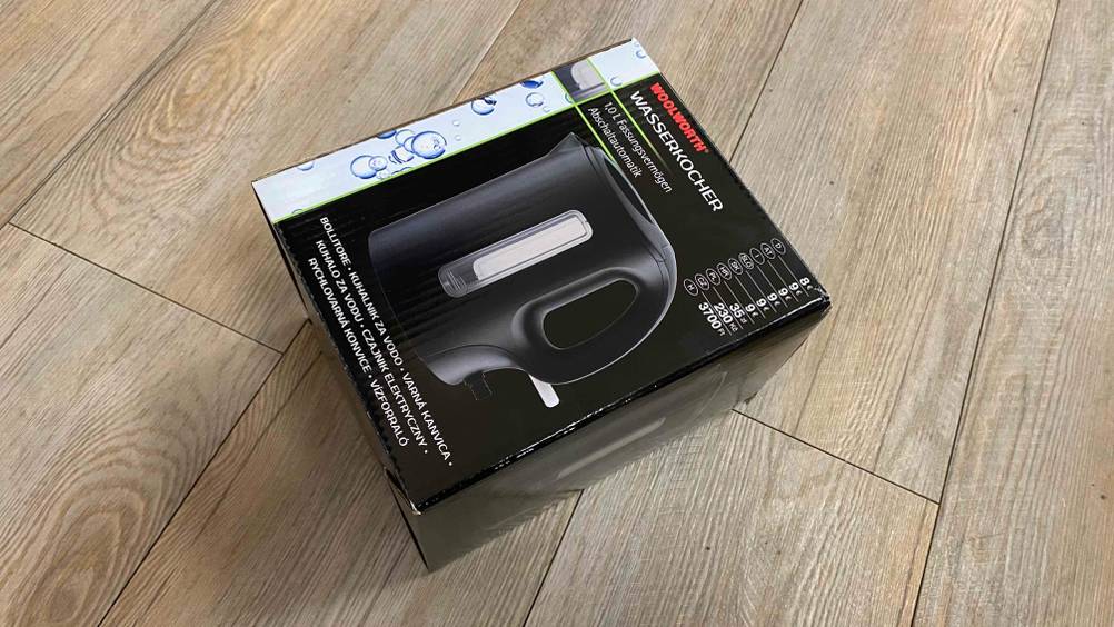 Die Originalverpackung eines getesteten Wasserkocher 1 Liter schräg auf einem Holzboden.