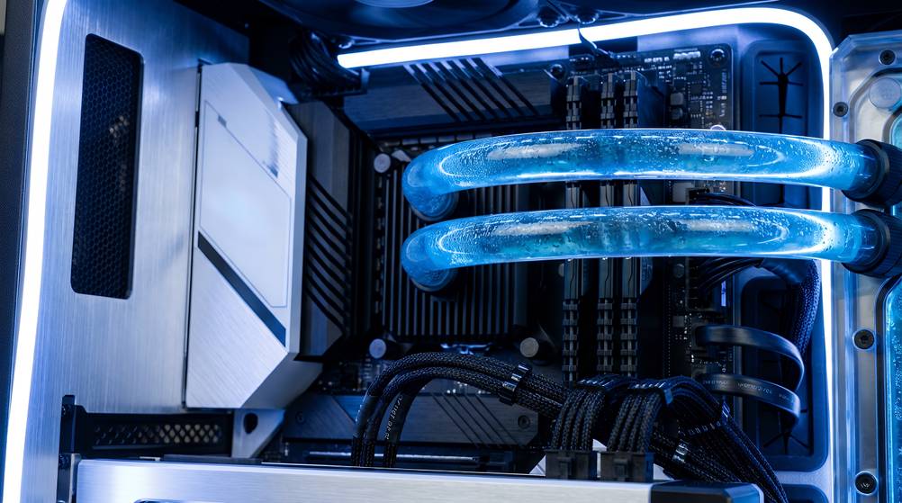 Detailansicht der Wasserkühlung eines getesteten Gaming-PC-Set. Das Innere des PCs ist blau beleuchtet.