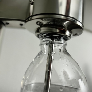 Eine Sprudelflasche ist leicht schräg in den Aarke Carbonator 3 eingesetzt.