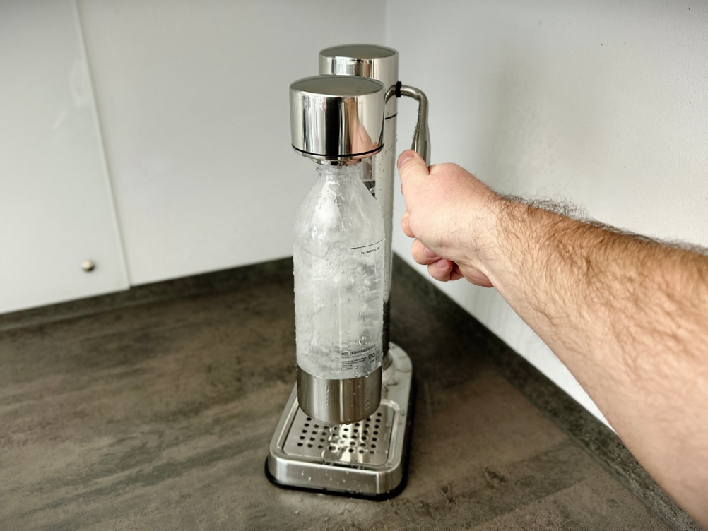 Eine Flasche mit sprudelndem Wasser im Aarke Carbonator 3 Wassersprudler während der Kohlensäurezufuhr.