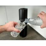 Sprudelwasser wird aus einer Sodastream-Flasche in ein Glas gegossen. Der Sodastream Terra steht im Hintergrund auf der Arbeitsplatte.