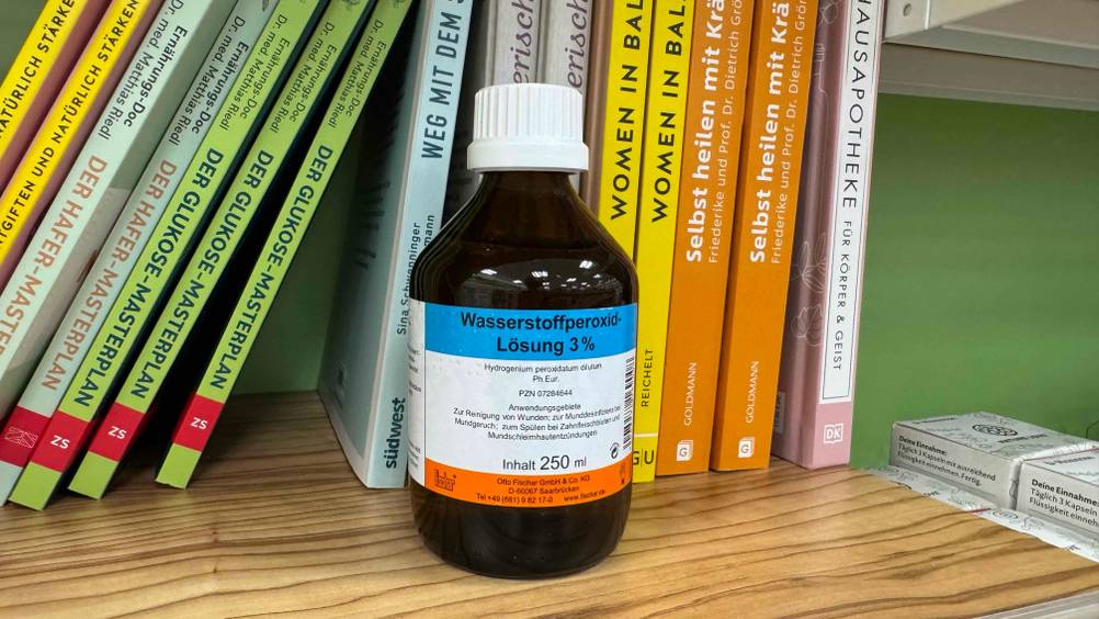Eine Flasche des getesteten Wasserstoffperoxid 3 Prozent vor mehreren Büchern.