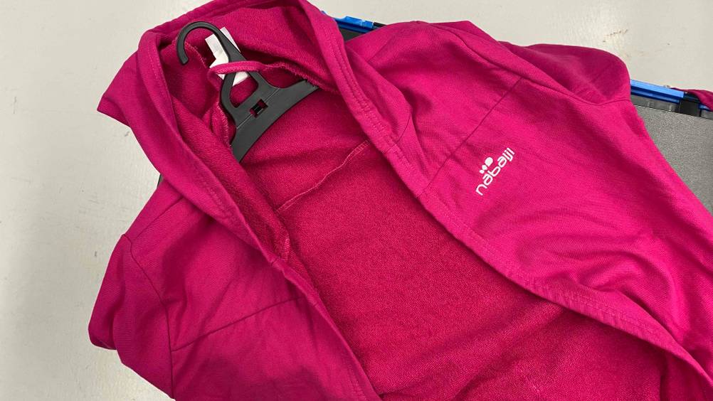 Rosa Damen-Bademantel im Test auf einem schwarzen Bügel vor hellem Hintergrund.