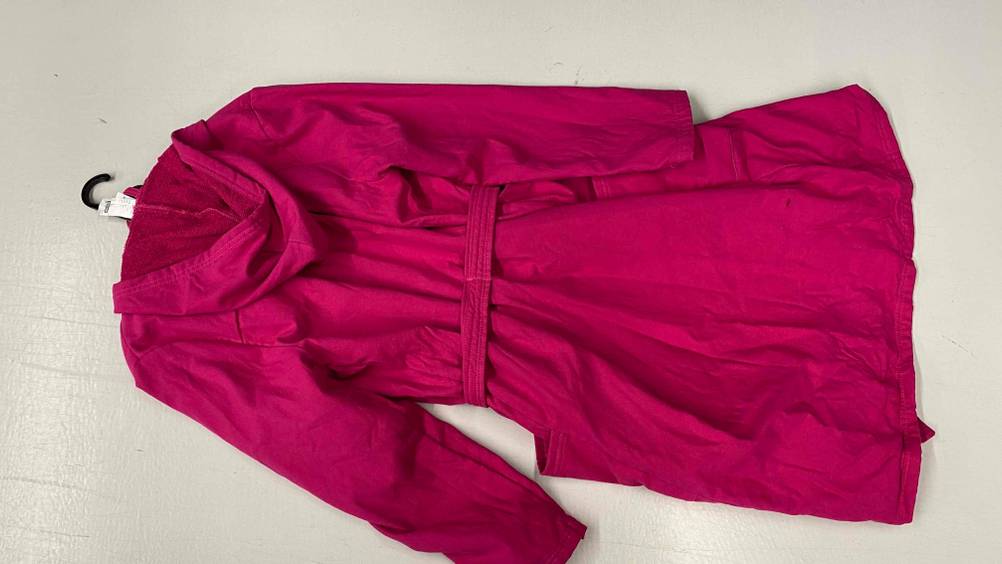 Ein rosa getesteter Damen-Bademantel mit Kapuze liegt ausgebreitet auf einem hellen Untergrund.