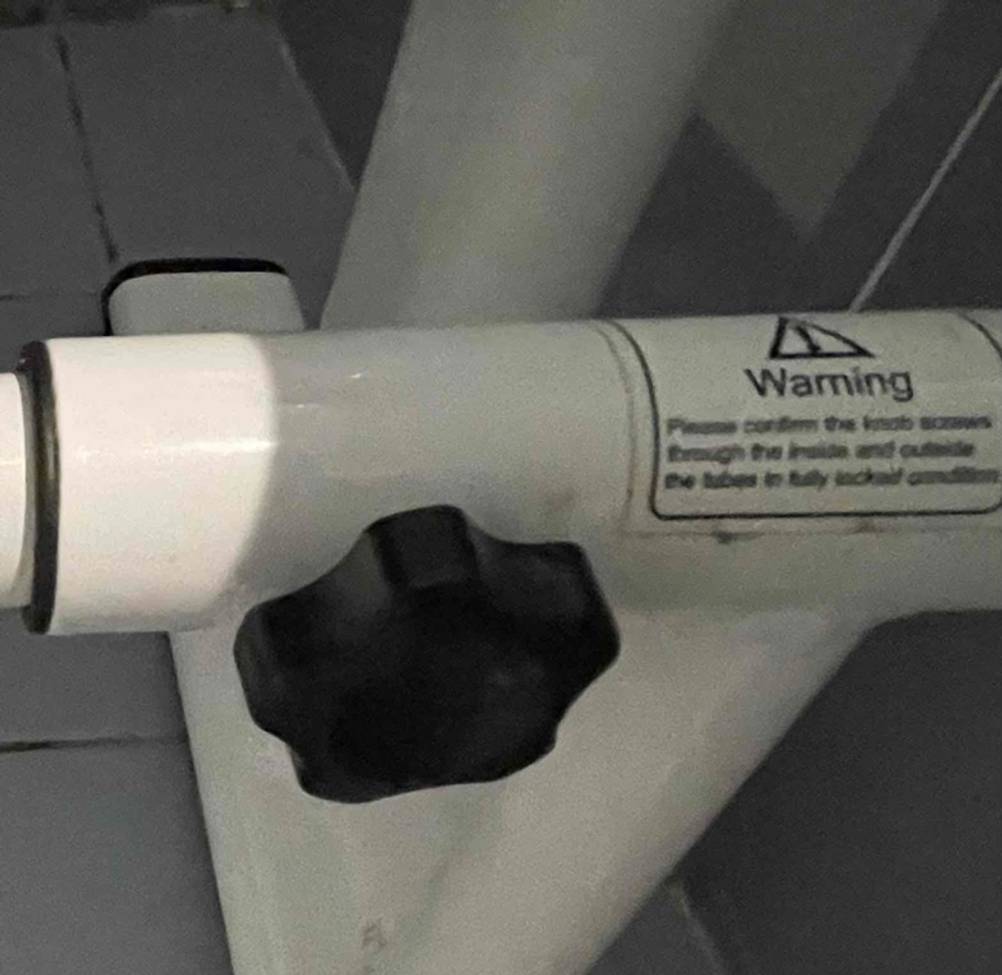 Nahaufnahme einer Stellschraube am Gestänge einer WC-Aufstehhilfe.