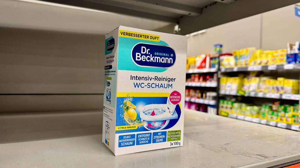 In einem Regal steht eine Packung des getesteten WC-Schaums, im Hintergrund Regale.