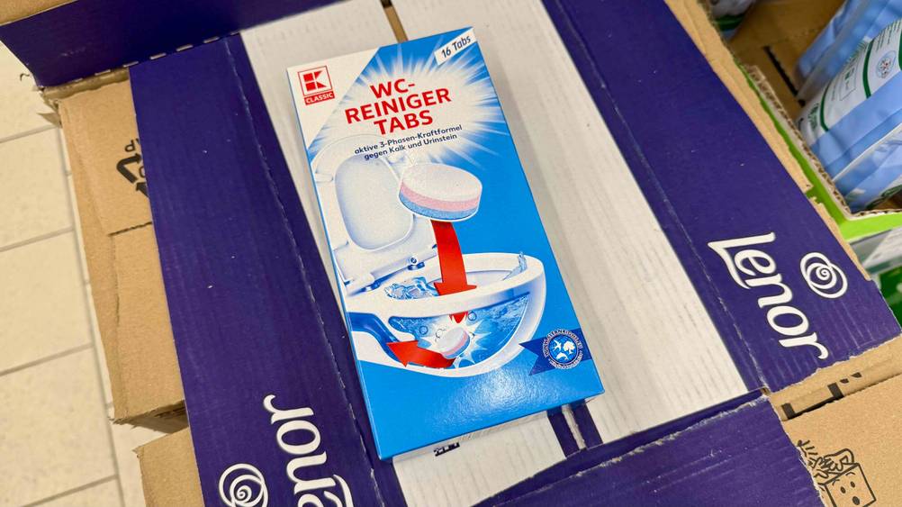 Auf einem Karton liegt eine Packung WC-Tabs im Test.