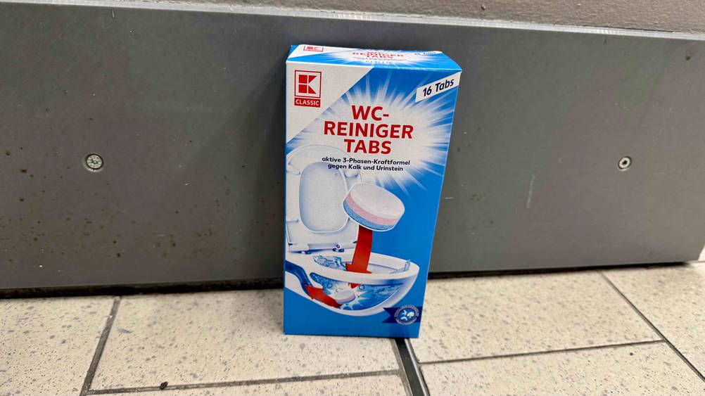 Die getesteten WC-Tabs vor einer grauen Fläche auf dem Boden stehend.