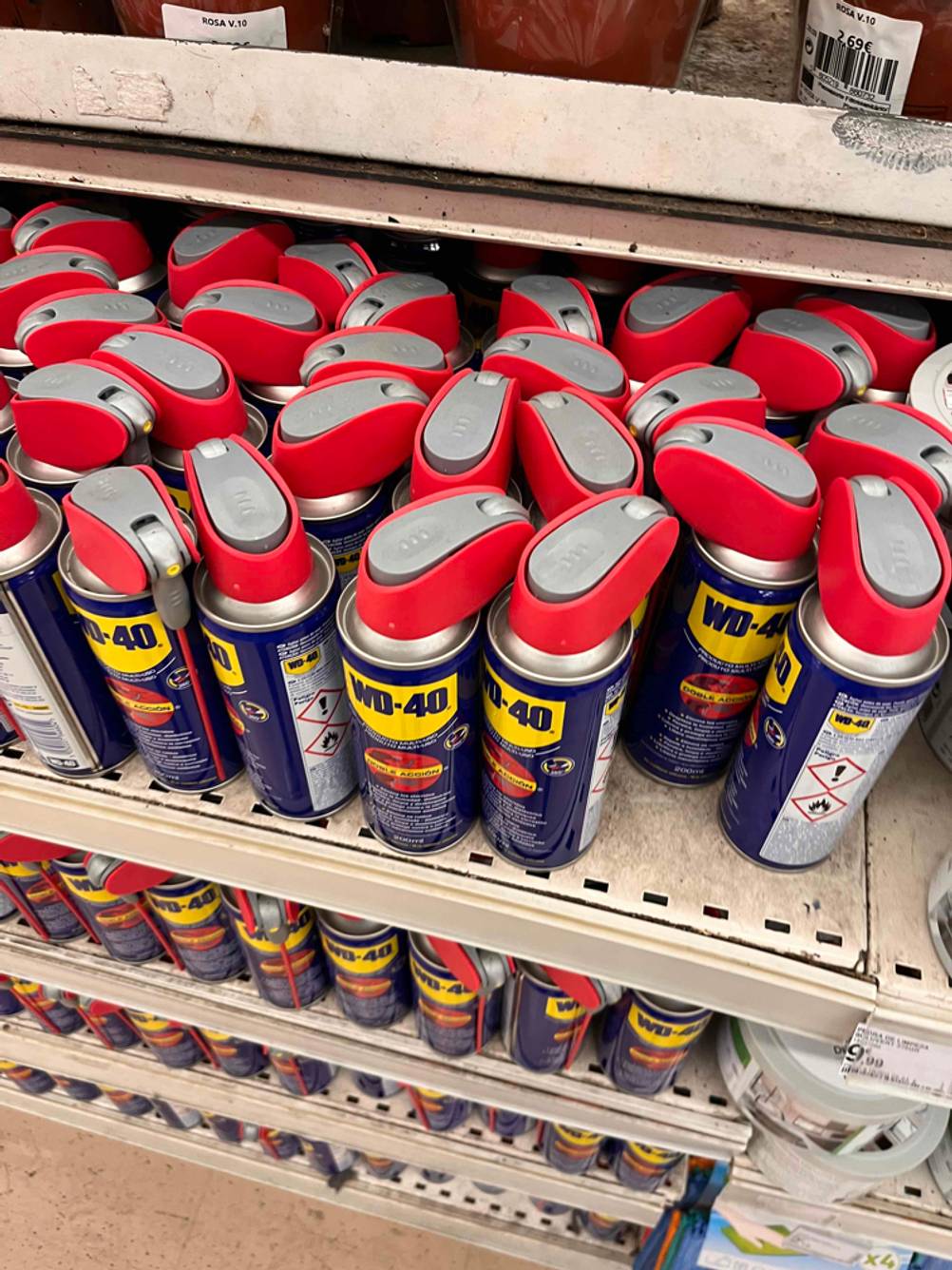 Eine große Menge an testbaren Druckluftsprays von WD 40 inklusive handlicher Sprühköpfe befindet sich auf einem Verkaufsregal.