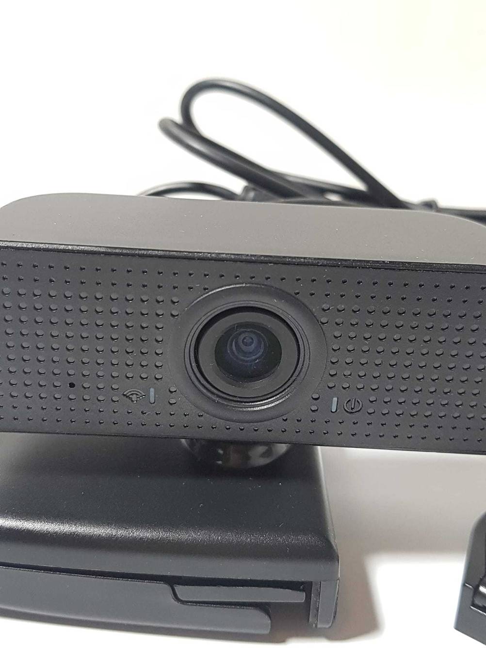 Nahaufnahme der Kamera einer getesteten Webcam mit Mikrofon auf einer hellen Fläche.