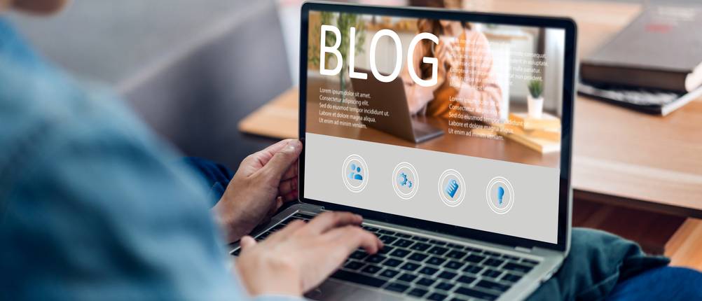 Webhosting getestet: Eine Person verwendet einen Laptop, auf dem gerade ein Blog geöffnet wird.