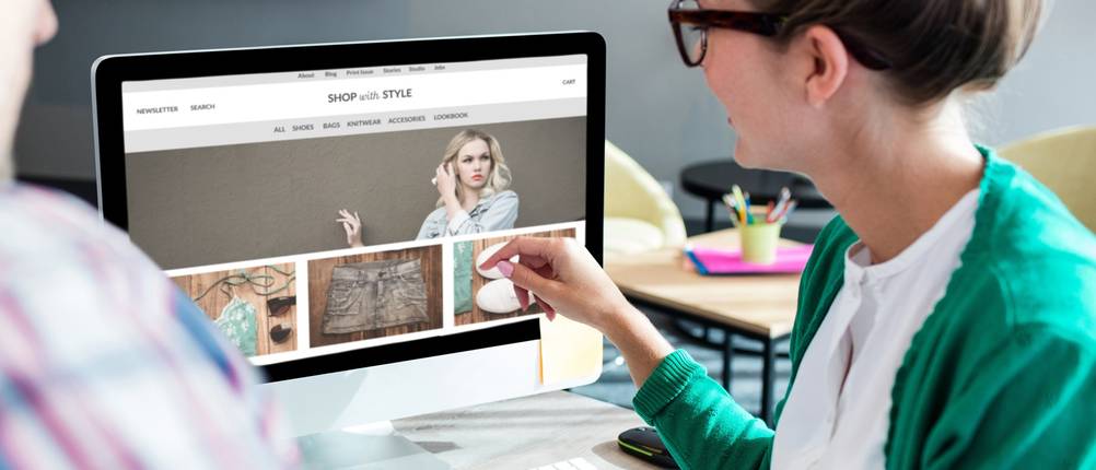 Website erstellen: Frau sitzt vor Laptop mit stylischem Websitendesign.