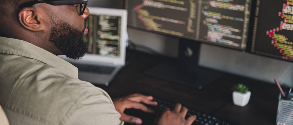 Website erstellen: Mitarbeiter programmiert HTML-Code.