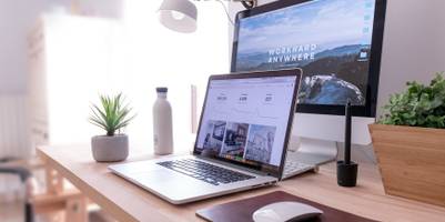 Websiten-Erstellung: Laptop geöffnet und an Monitor angeschlossen.