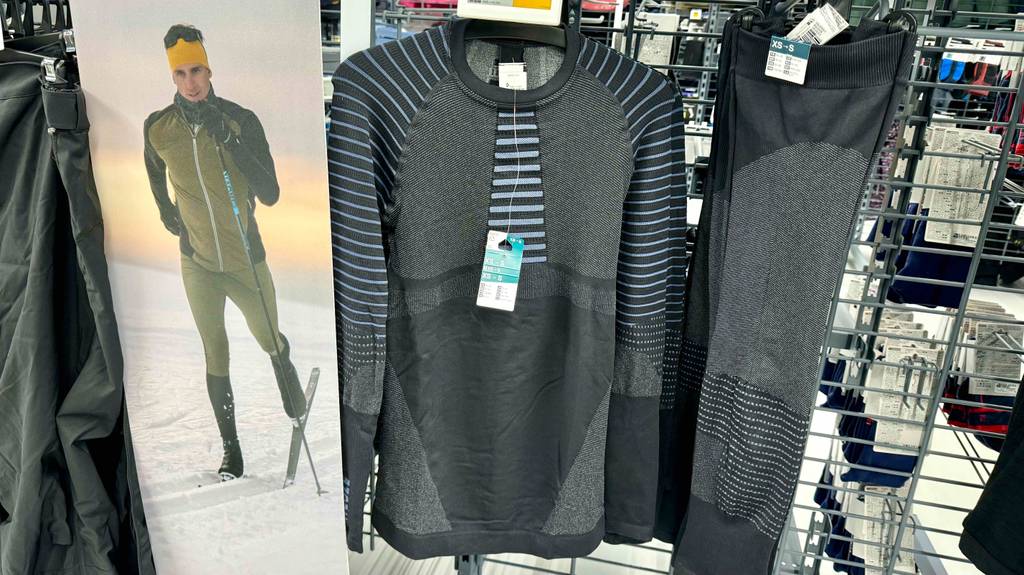 Ski-Unterwäsche für Herren im Test: Ein Set in schwarz hängt in einem Regal.