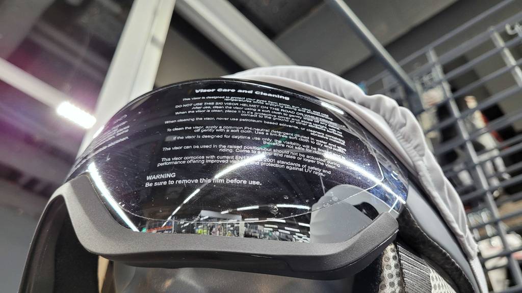 Detailansicht des mit Schutzfolie abgeklebten Visier eines Skihelms mit Visier im Test.