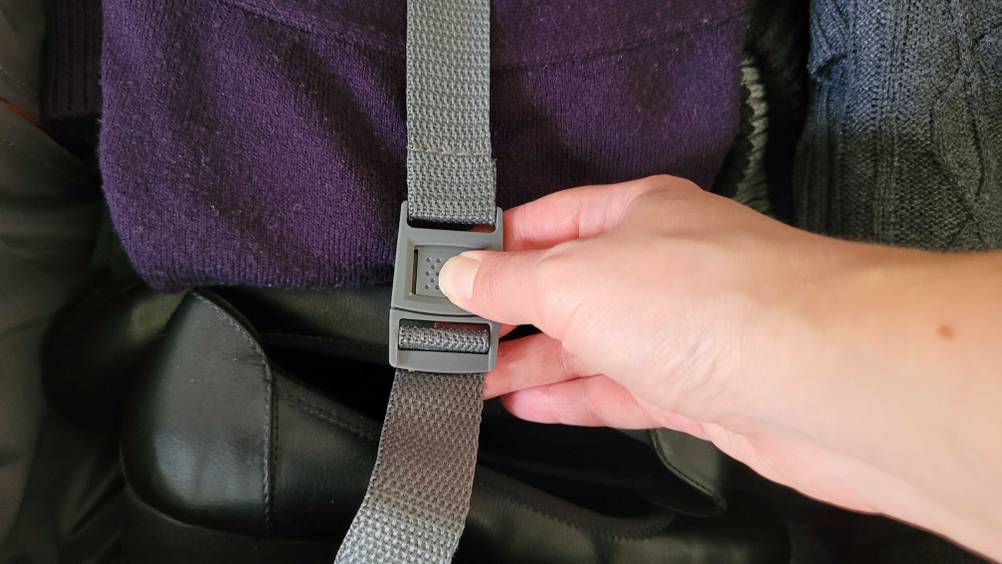 Nahaufnahme einer Schnalle eines Weichschalenkoffers im Test die von einer Hand geöffnet wird.