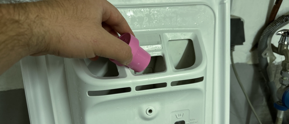 Veganer Weichspüler von Ecover wird in die Waschmaschine gefüllt.