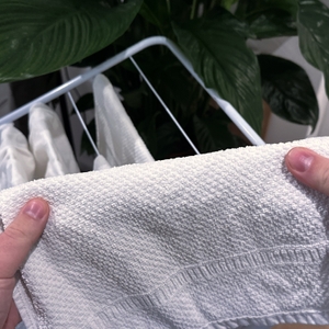 Ein Handtuch wird vor einem Wäscheständer hochgehalten.