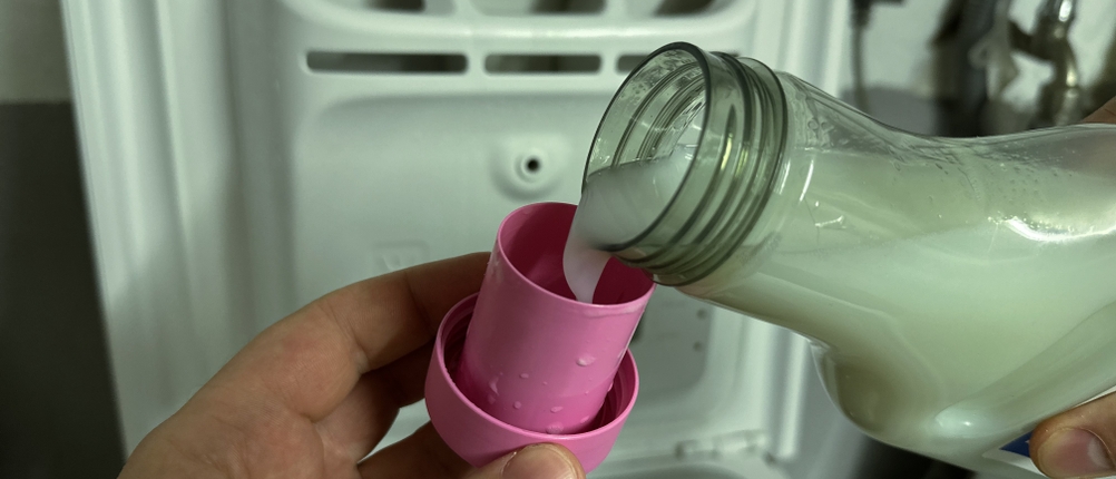 Der vegane Weichspüler von Ecover wird in die Dosierkappe gefüllt.